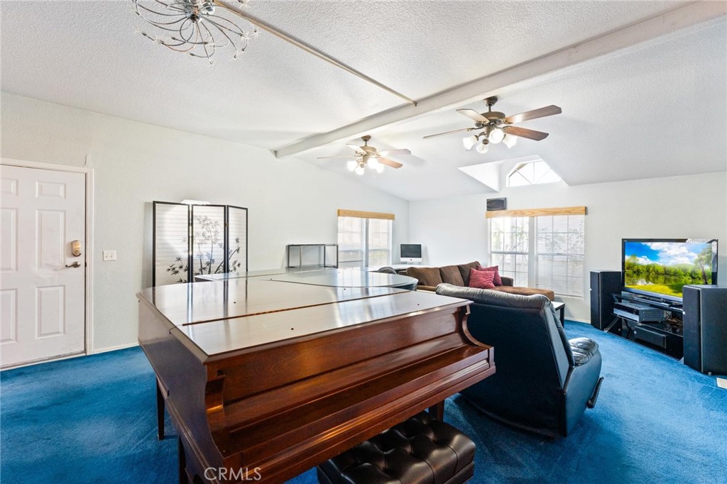 23301 Ridge Rte Drive, Unit 165 Laguna Hills, CA 92653 - Photo 4 of 31 a living room with furniture a flat screen tv and a chandelier