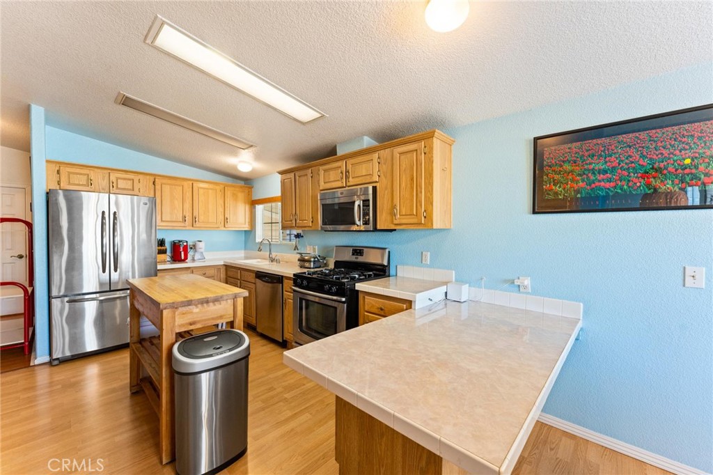 23301 Ridge Rte Drive, Unit 165 Laguna Hills, CA 92653 - Photo 9 of 31 a kitchen that has a microwave a stove and a refrigerator