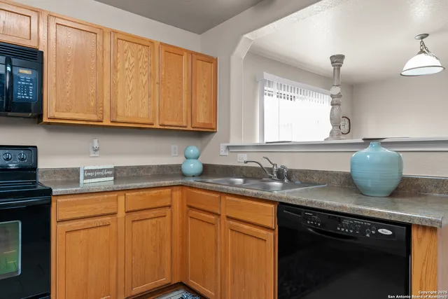 a kitchen with granite countertop a sink stainless steel appliances and cabinets