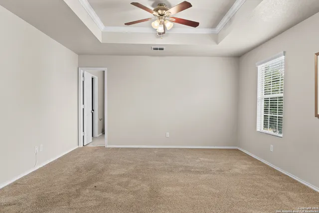 an empty room with a window and a fan