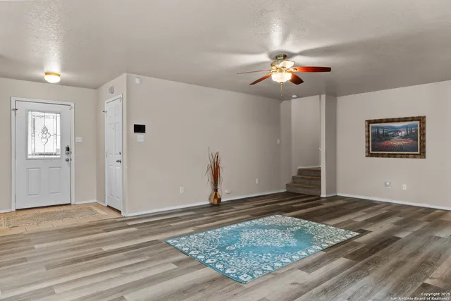 a view of a livingroom with wooden floor and a ceiling fan