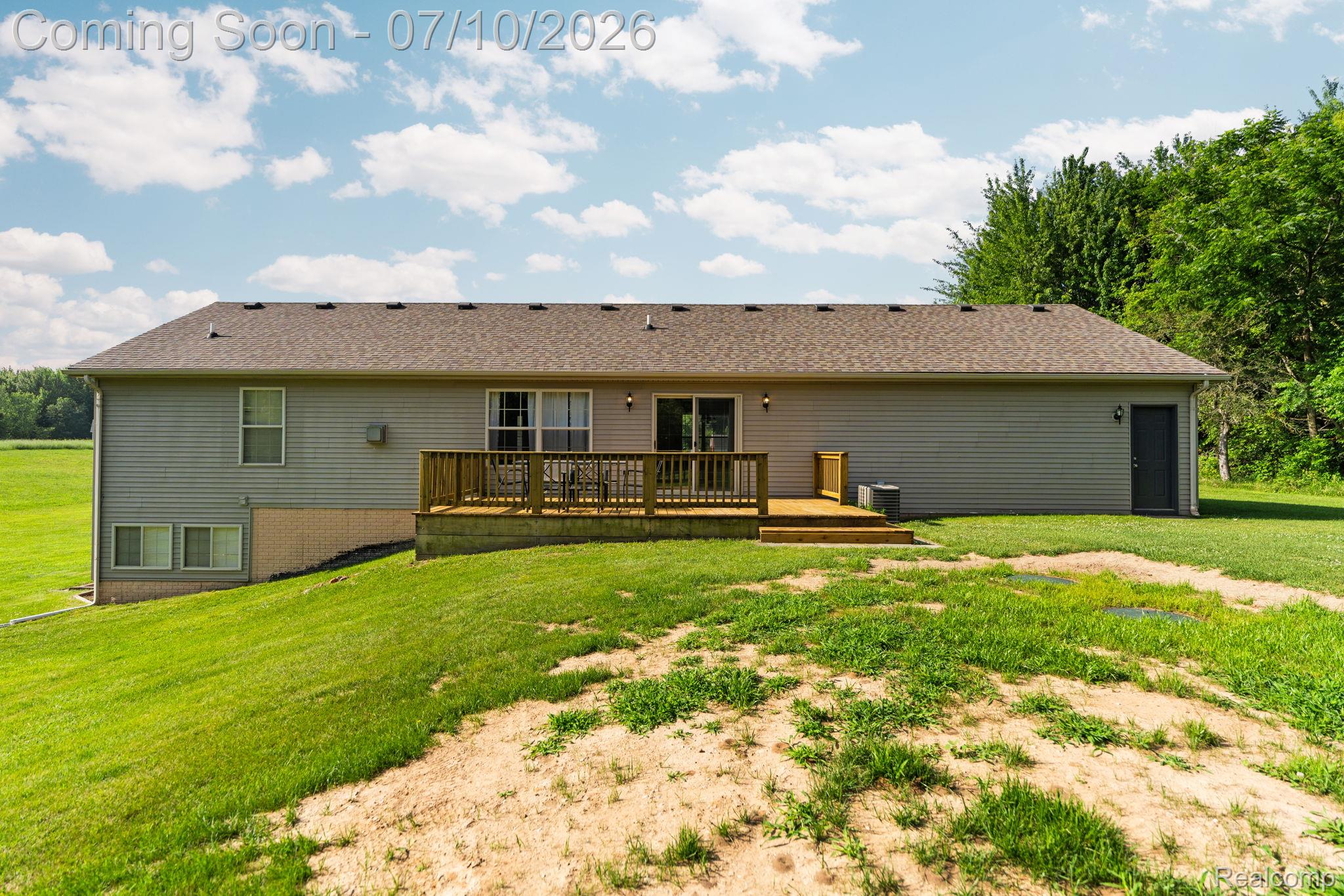 3144 North Nicholson Road Fowlerville, MI 48836 - Photo 24 of 70 Rear exterior featuring a wood deck, sliding glass door, and a walk-out basement