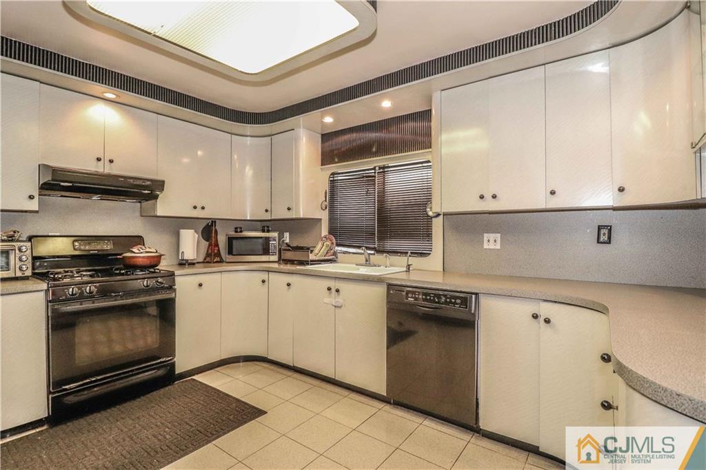 99 Ashley Road Edison, NJ 08817 - Photo 13 of 38 a kitchen with granite countertop white cabinets and stainless steel appliances
