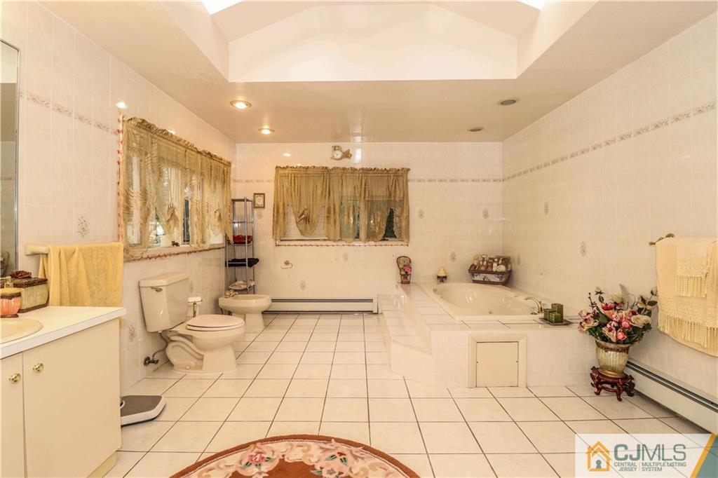 99 Ashley Road Edison, NJ 08817 - Photo 25 of 38 a bathroom with a sink a toilet and a mirror