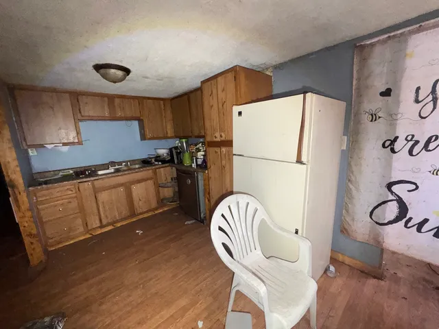 a kitchen with stainless steel appliances granite countertop a refrigerator a sink a stove and a refrigerator