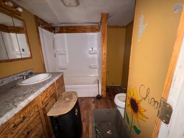 a bathroom with a granite countertop sink a mirror and shower