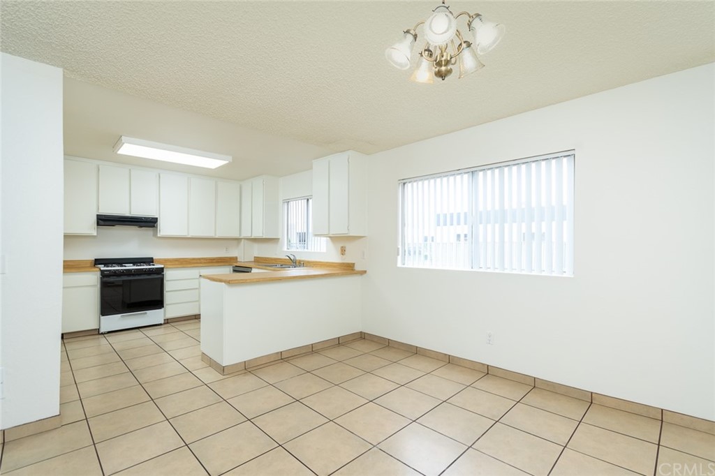 8865 Independence Avenue, Unit 26 Canoga Park, CA 91304 - Photo 8 of 40 a large white kitchen with a stove a sink dishwasher and a refrigerator