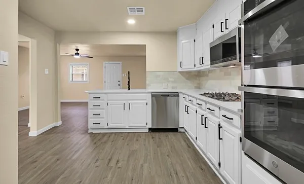 a kitchen with stainless steel appliances a stove microwave and cabinets