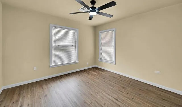 a view of room with window ceiling fan and hardwood floor