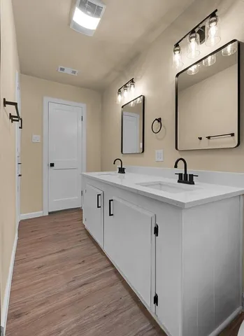 a bathroom with a double vanity sink and a mirror