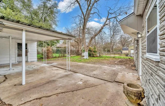 a view of a house with backyard and a tree