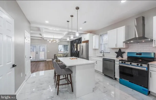 a kitchen with refrigerator a stove a sink cabinets and a dining table