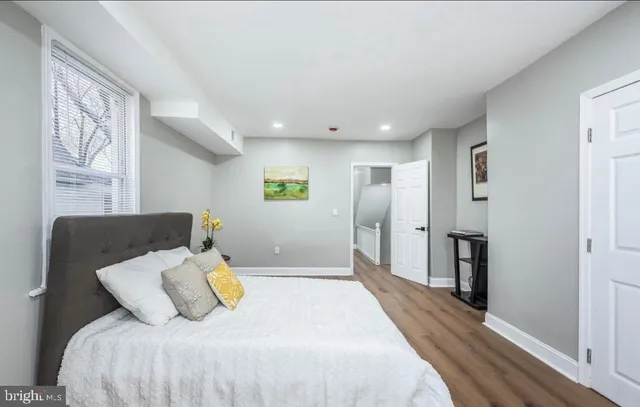a bedroom with a bed and wooden floor