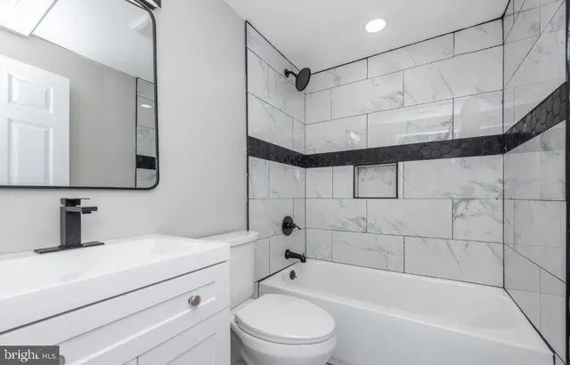 a bathroom with a bathtub shower sink vanity and toilet