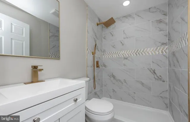 a bathroom with a sink toilet vanity and shower