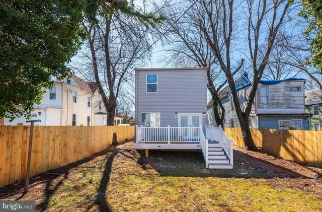 a view of backyard with wooden fence and large trees