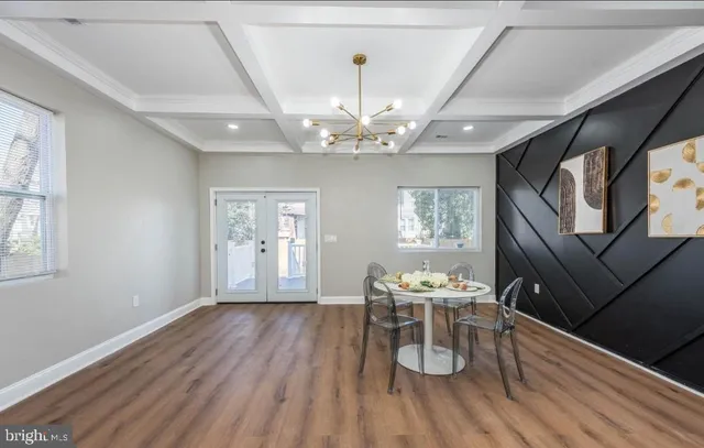 a view of a dining room with furniture a chandelier and wooden floor