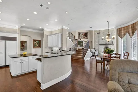 a view of a dining room and livingroom with furniture wooden floor a chandelier