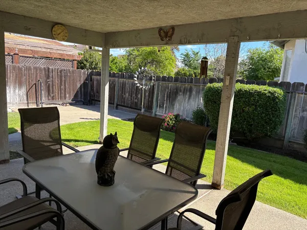 a view of a chairs and table in patio with a backyard