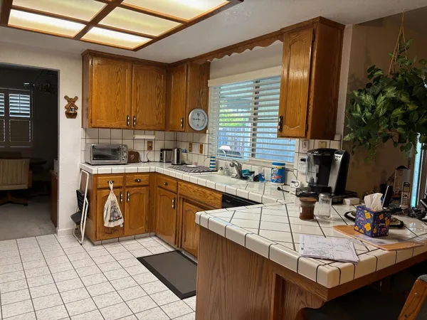 a kitchen with a sink a stove cabinets and a window