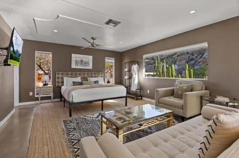 a bedroom with a bed and painting on the wall