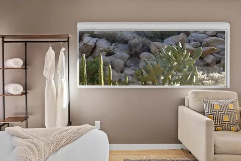 a bedroom with a bed a large window and couch