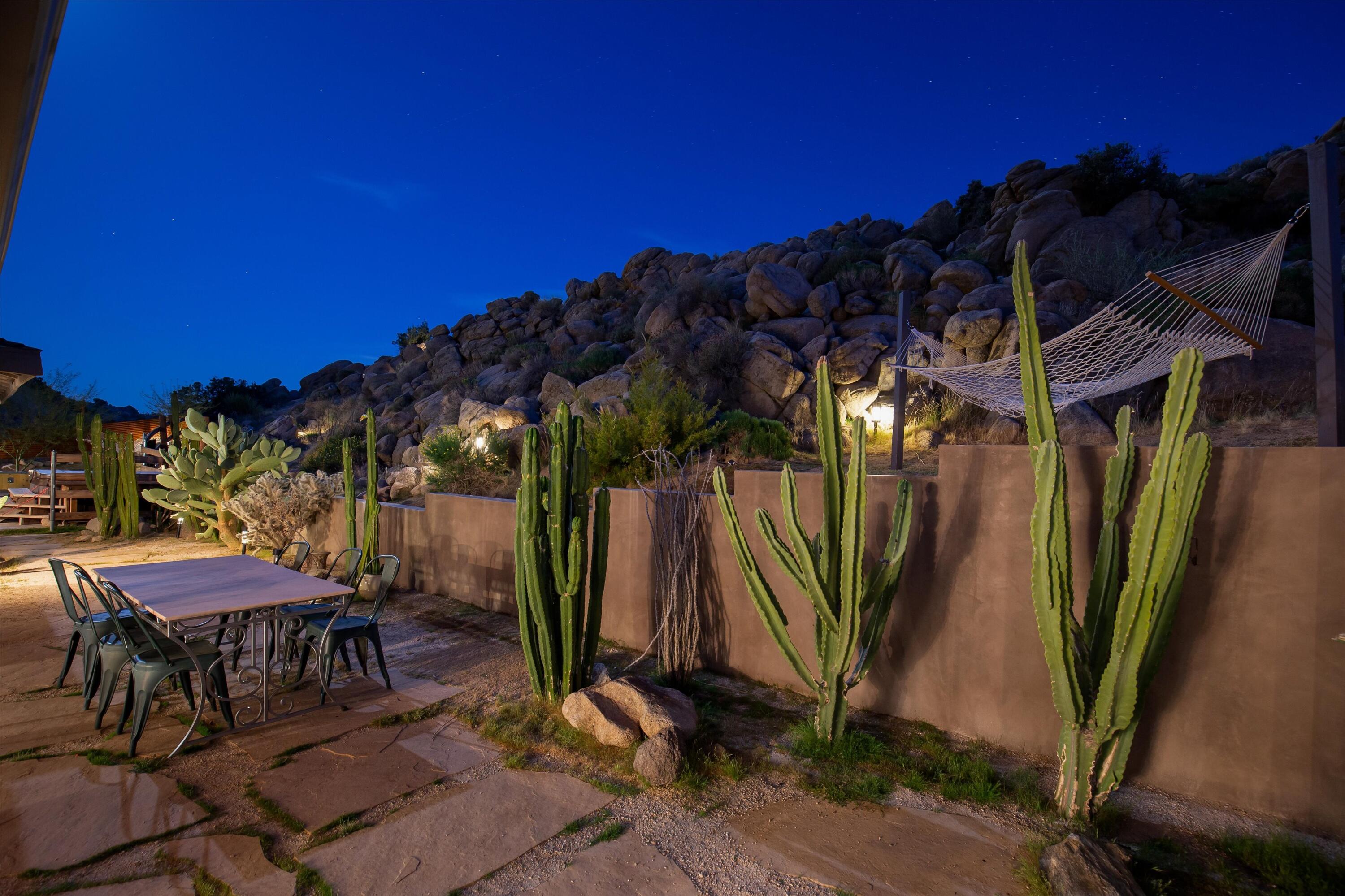 57113 Farrelo Road Yucca Valley, CA 92284 - Photo 39 of 50 a view of a patio with table and chairs under an umbrella with palm trees