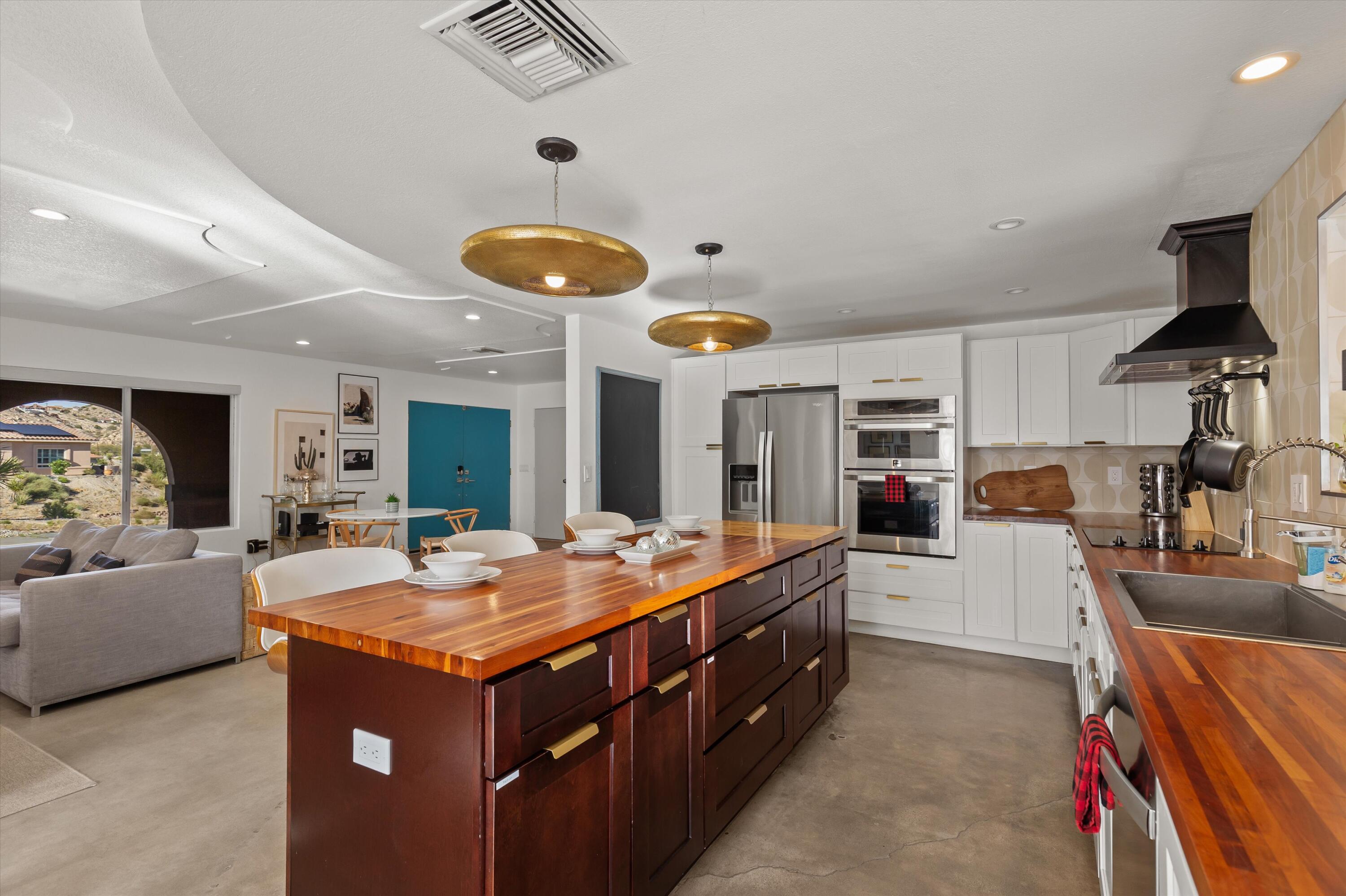 57113 Farrelo Road Yucca Valley, CA 92284 - Photo 9 of 50 a dining hall with stainless steel appliances granite countertop a stove and cabinets