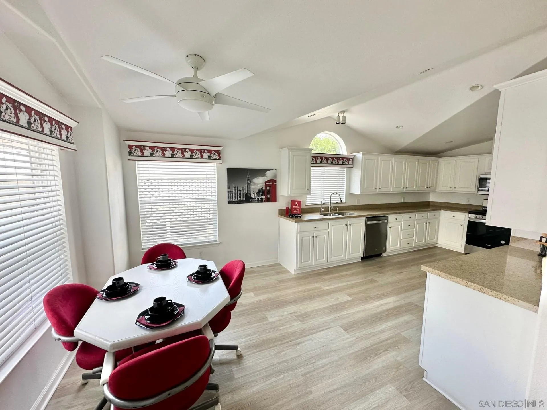 13307 Alpine Drive, Unit 2 Poway, CA 92064 - Photo 13 of 13 a kitchen with stainless steel appliances kitchen island granite countertop a stove a sink dishwasher and a dining table with wooden floor
