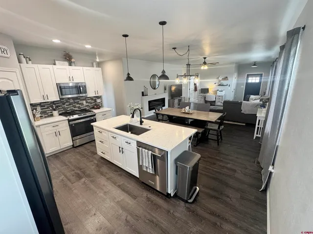 a kitchen with a stove a refrigerator and a wooden floor