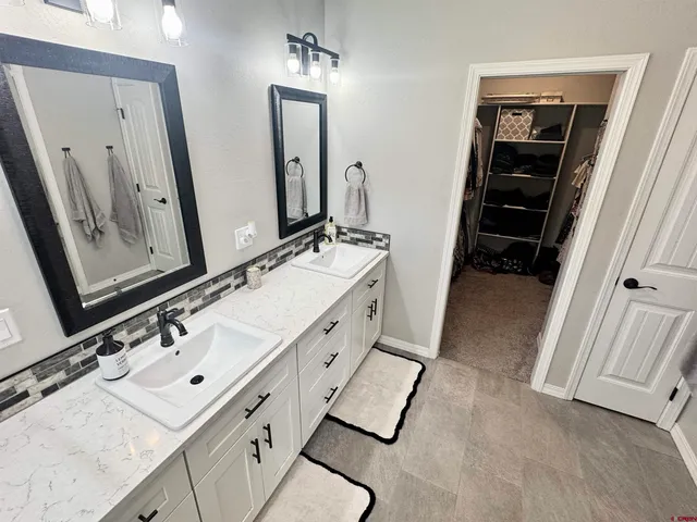 a spacious bathroom with a double vanity sink and mirror