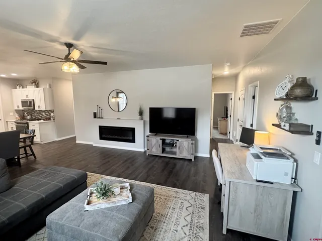 a living room with furniture a flat screen tv and a fireplace