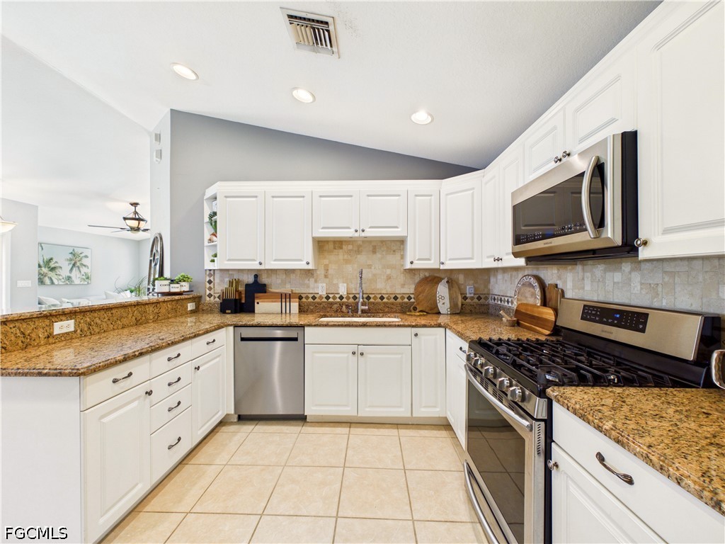 19694 Villa Rosa Loop Estero, FL 33967 - Photo 11 of 28 a kitchen with granite countertop white cabinets stainless steel appliances and a counter space