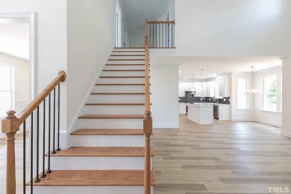 a view of an entryway with wooden floor and kitchen view