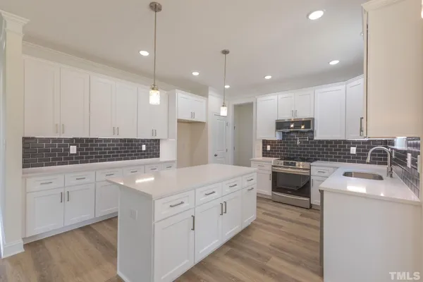 a kitchen with kitchen island granite countertop stainless steel appliances sink stove microwave and cabinets