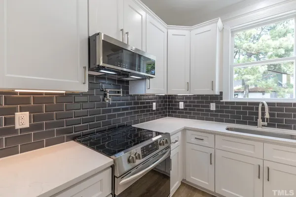 a kitchen with stainless steel appliances a sink a stove and microwave