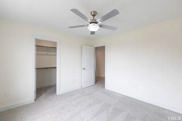 a view of an empty room with a ceiling fan