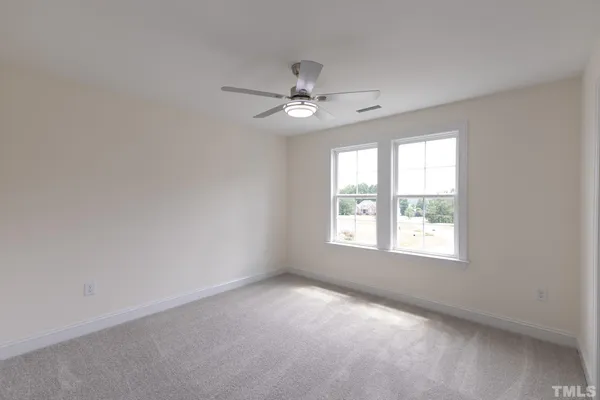 an empty room with a window and a fan