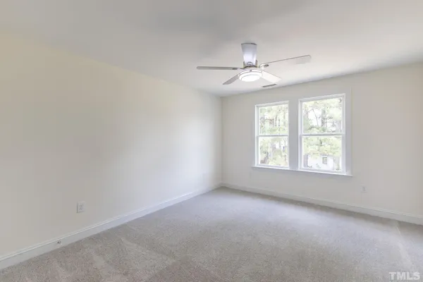 an empty room with a window and a fan