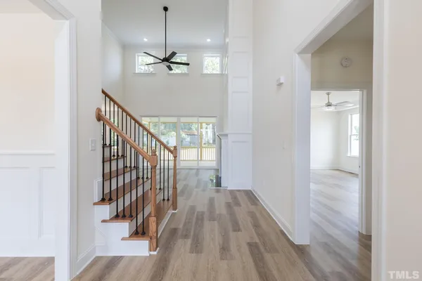 a view of a hallway with wooden floor and staircase