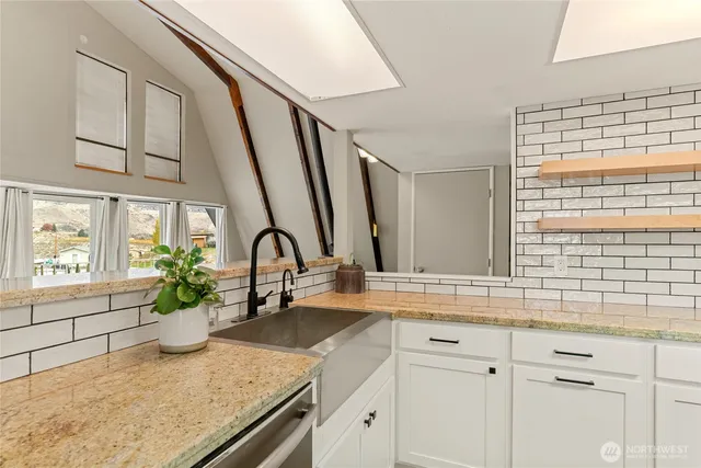 a kitchen with granite countertop a sink and a refrigerator