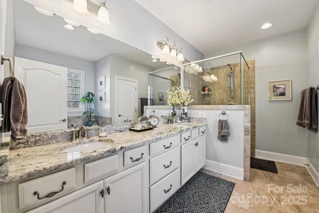 a spacious bathroom with a granite countertop sink mirror and a shower
