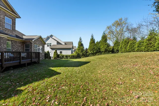 a view of a house with a big yard and large trees