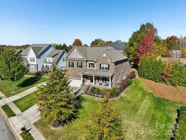 a aerial view of a house with a big yard and potted plants