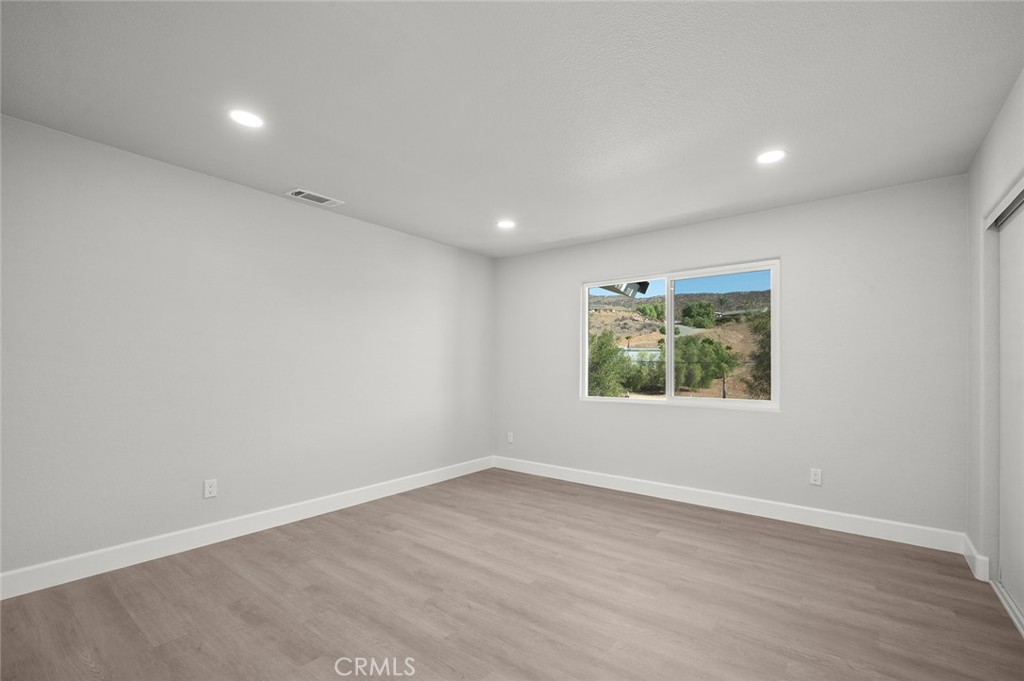 27875 Goetz Road Menifee, CA 92587 - Photo 23 of 74 an empty room with wooden floor and window