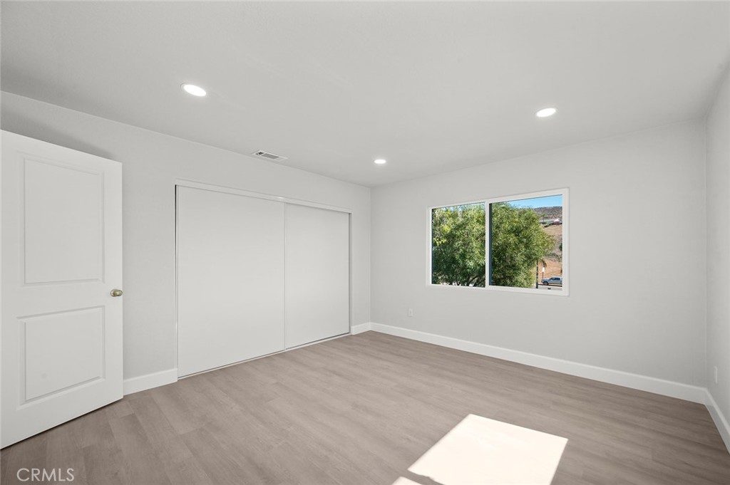 27875 Goetz Road Menifee, CA 92587 - Photo 26 of 74 an empty room with wooden floor and windows