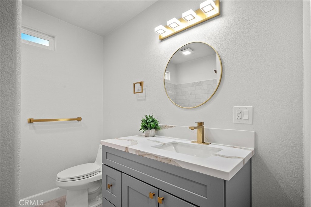 27875 Goetz Road Menifee, CA 92587 - Photo 27 of 74 a bathroom with a sink a toilet and a mirror