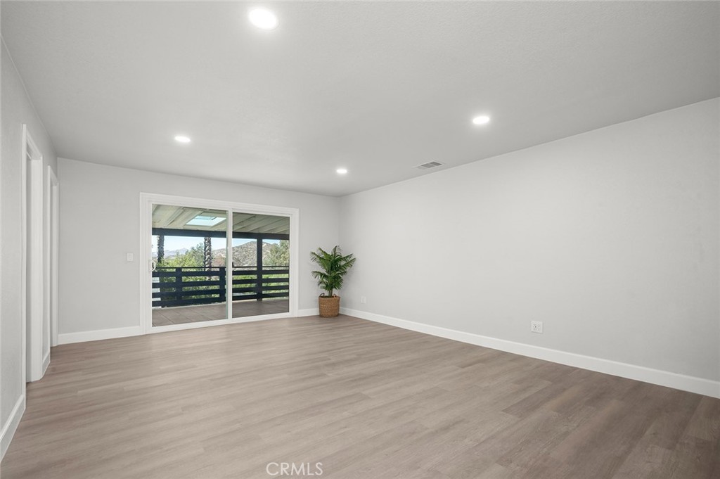 27875 Goetz Road Menifee, CA 92587 - Photo 29 of 74 an empty room with wooden floor and windows