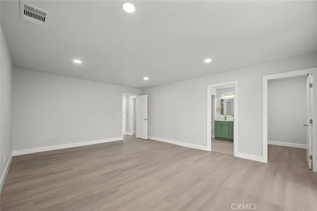 a large kitchen with kitchen island a sink stainless steel appliances and white cabinets