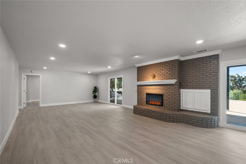 27875 Goetz Road Menifee, CA 92587 - Photo 38 of 74 an empty room with wooden floor fireplace and windows